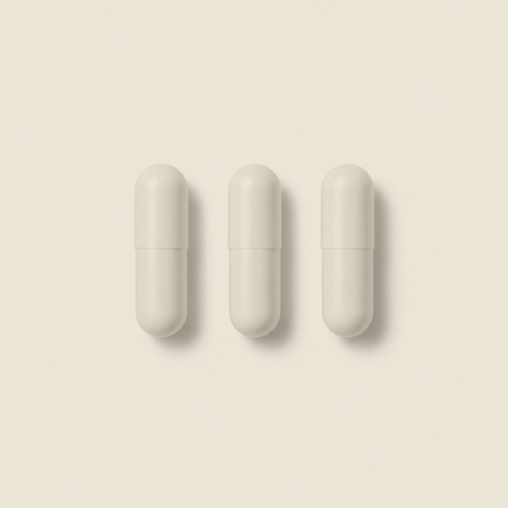 Three Nightly Basics magnesium glycinate capsules in a row, one nightly serving.